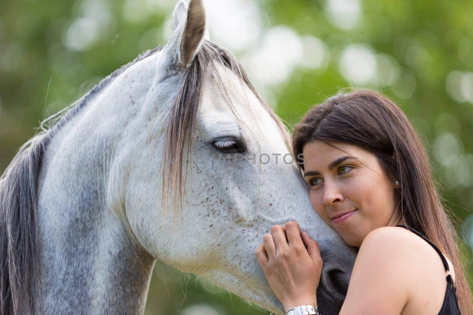 Happy young woman with her horse and strolling