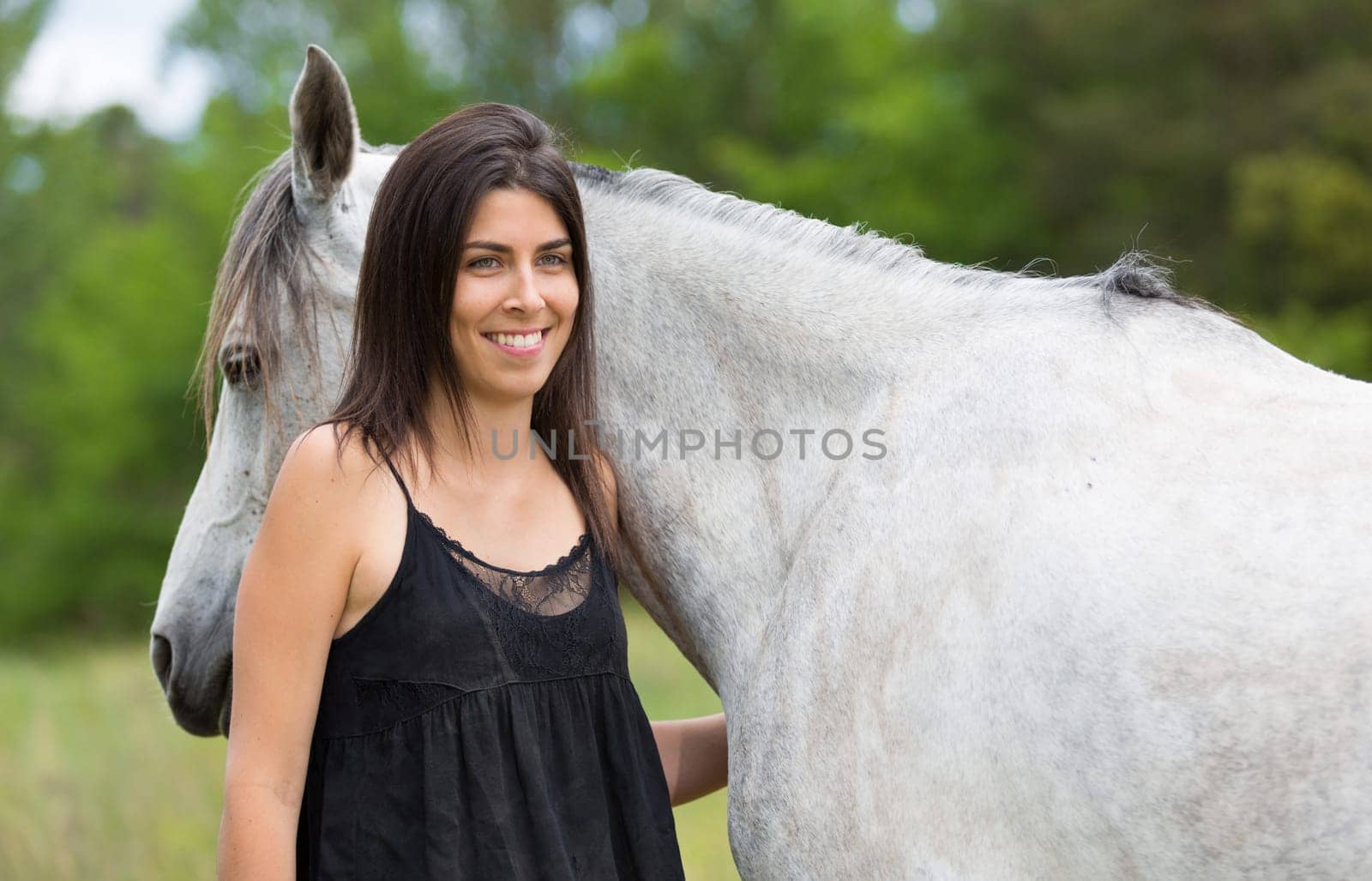 Happy young woman with her horse and strolling