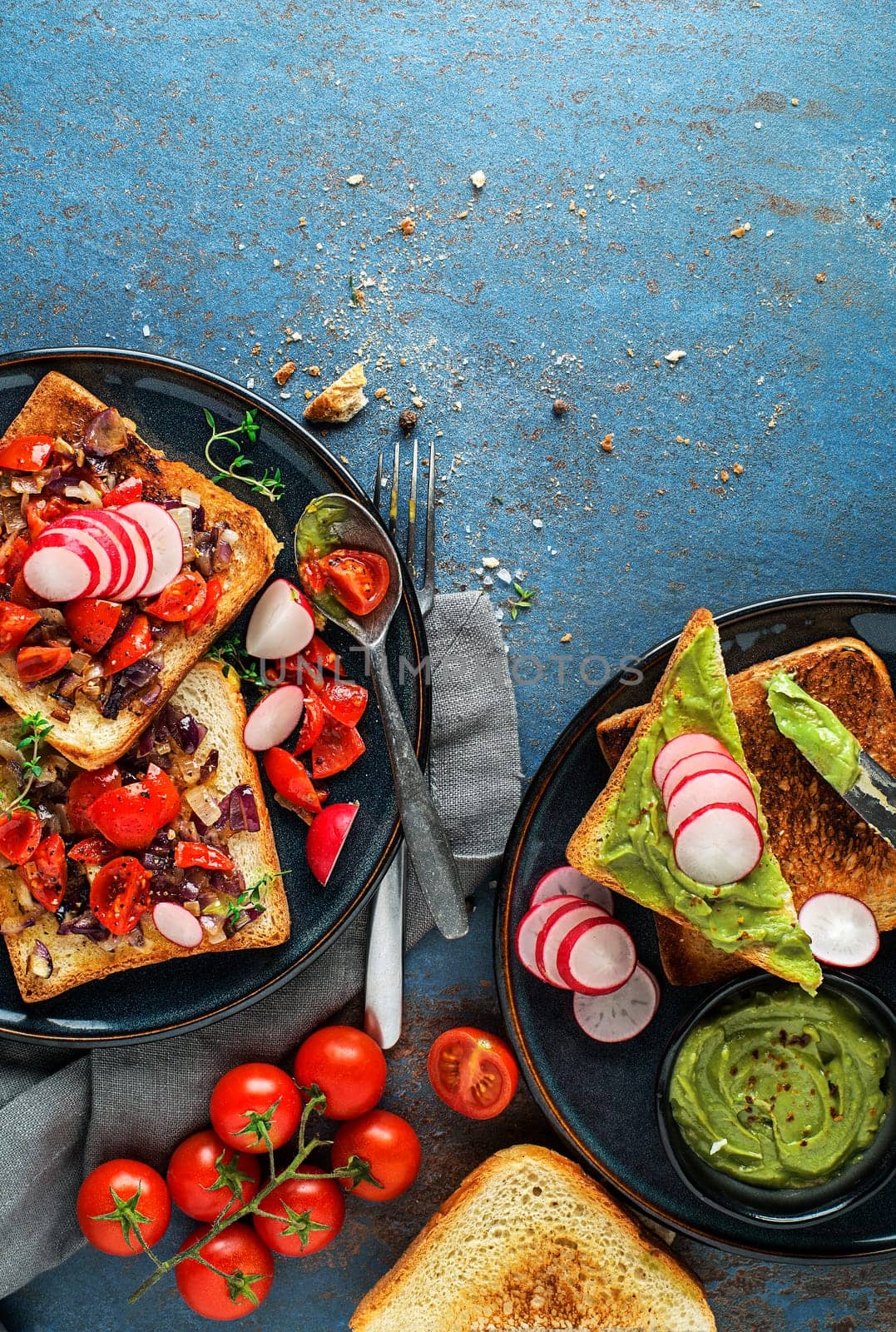 Breakfast served with toast sandwiches with avocado spread, tomato, onion and herbs.