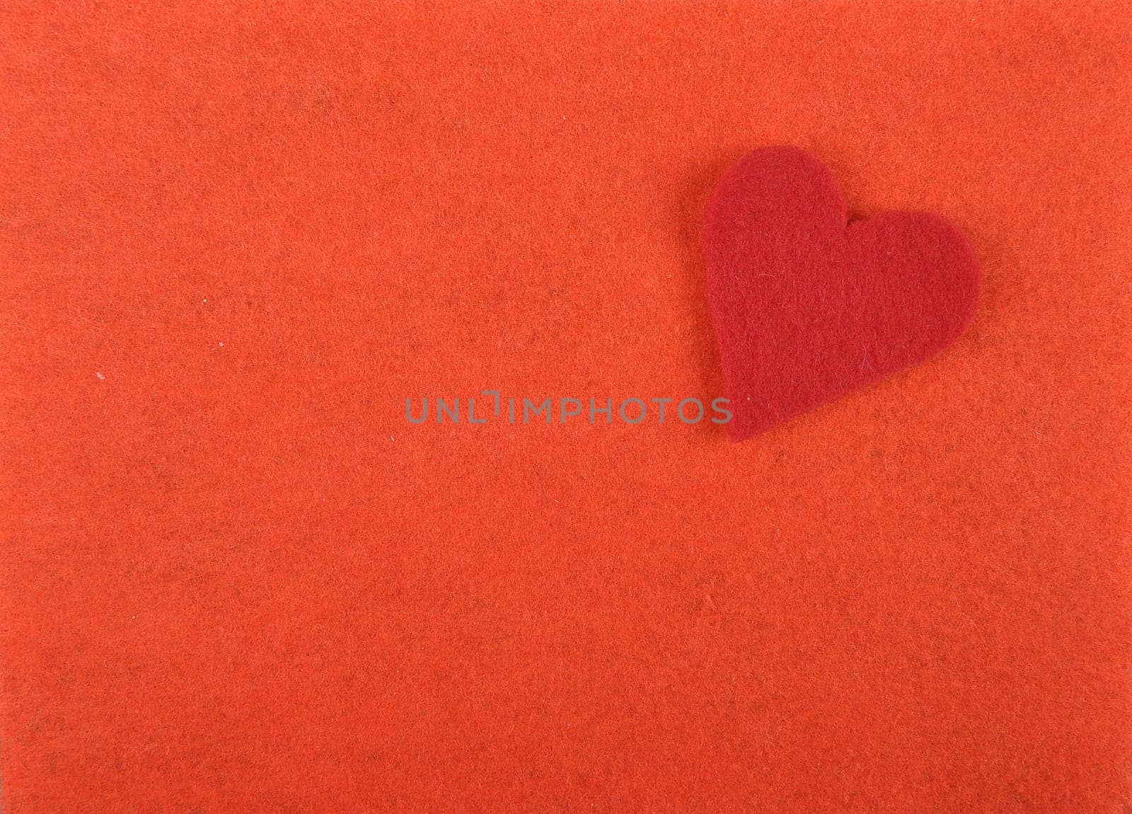 Heart of felt on red background