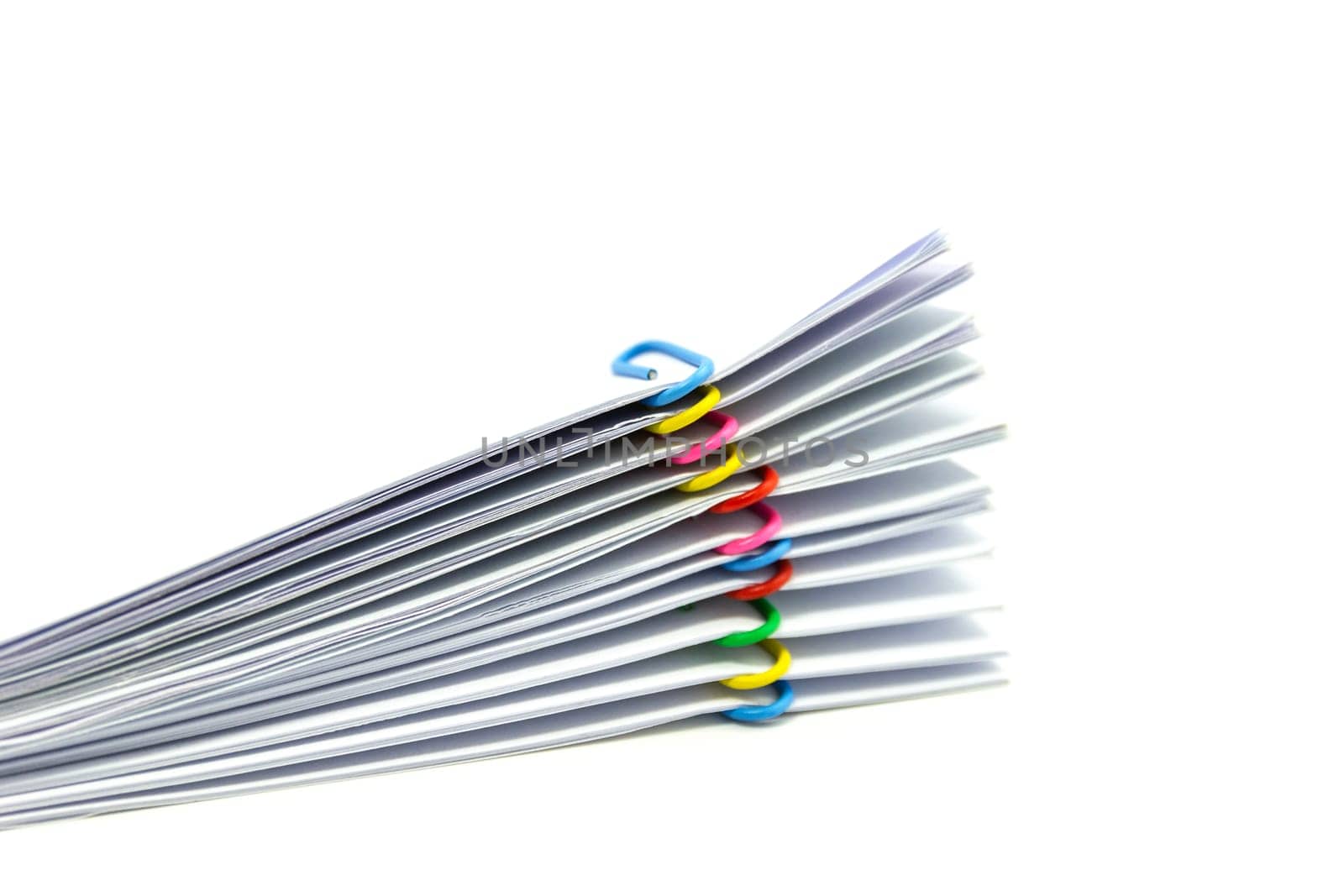 close up of Stack of papers files piles of unfinished documents achieves with paper clips .
