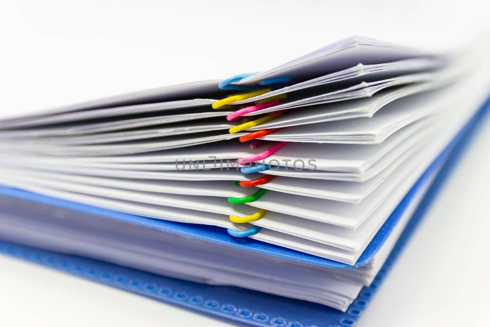 close up of Stack of papers files piles of unfinished documents achieves with paper clips .