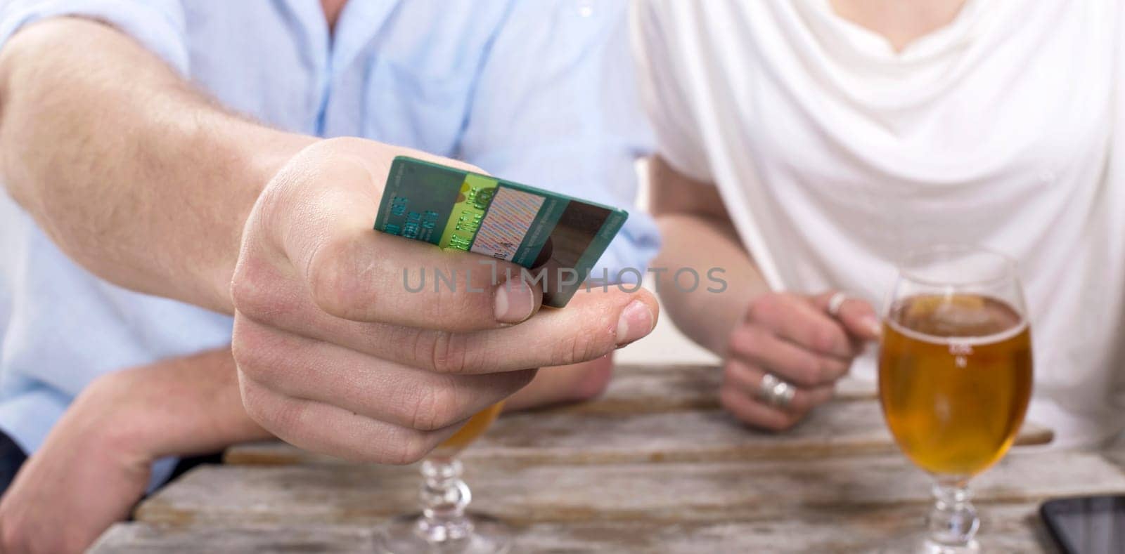 a young couple pays the drink bill with credit card