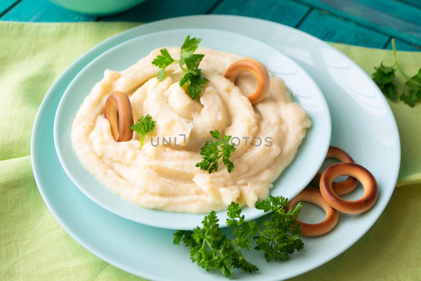 Homemade mashed potatoes in a bowl with parsley and russian bublik.