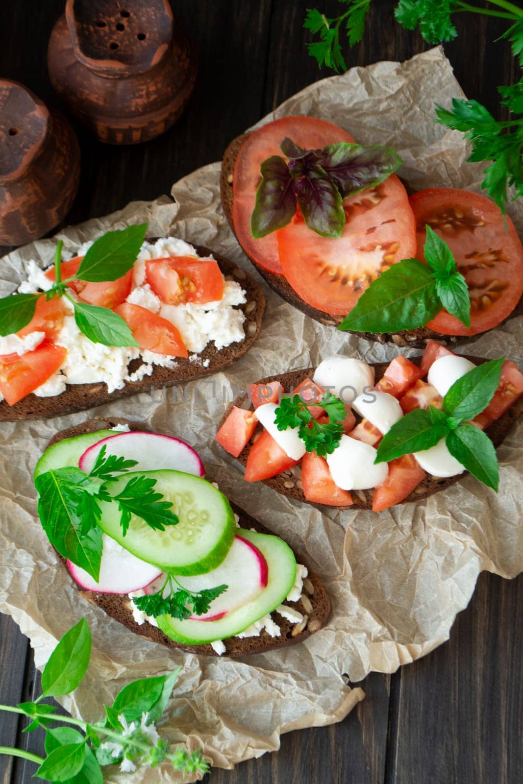 Italian bruschetta with tomatoes, parmesan, cucumber, basil, mozarella, garlic and olive oil. Mix bruschetta flat lay