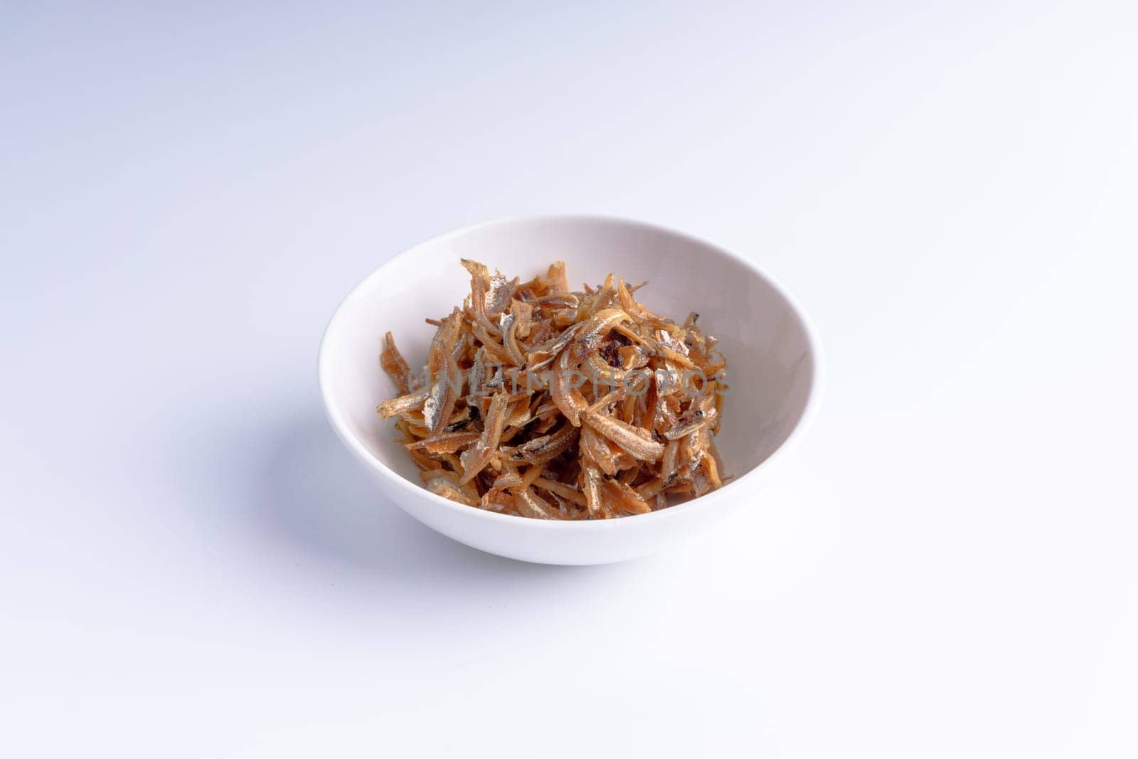 Fried anchovies in bowl close up with selective focus and crop fragment