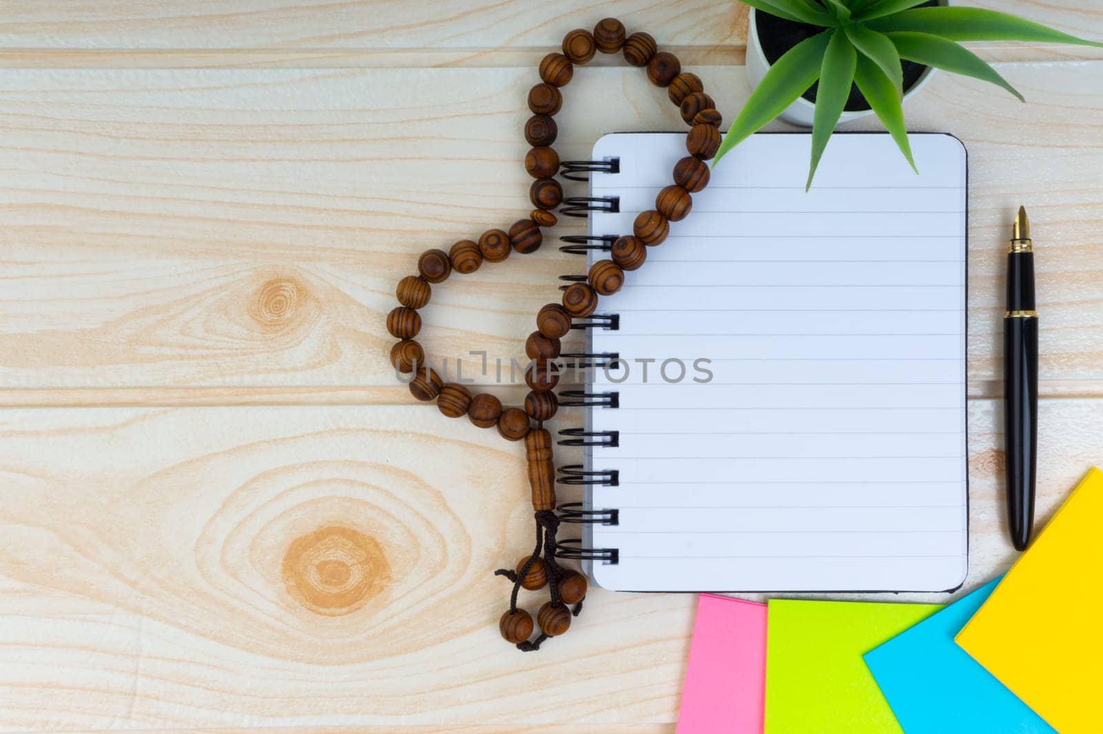 Workspace with Pen, spectacles, decoration flower, rosary and book.Copy Space, business and education concept.