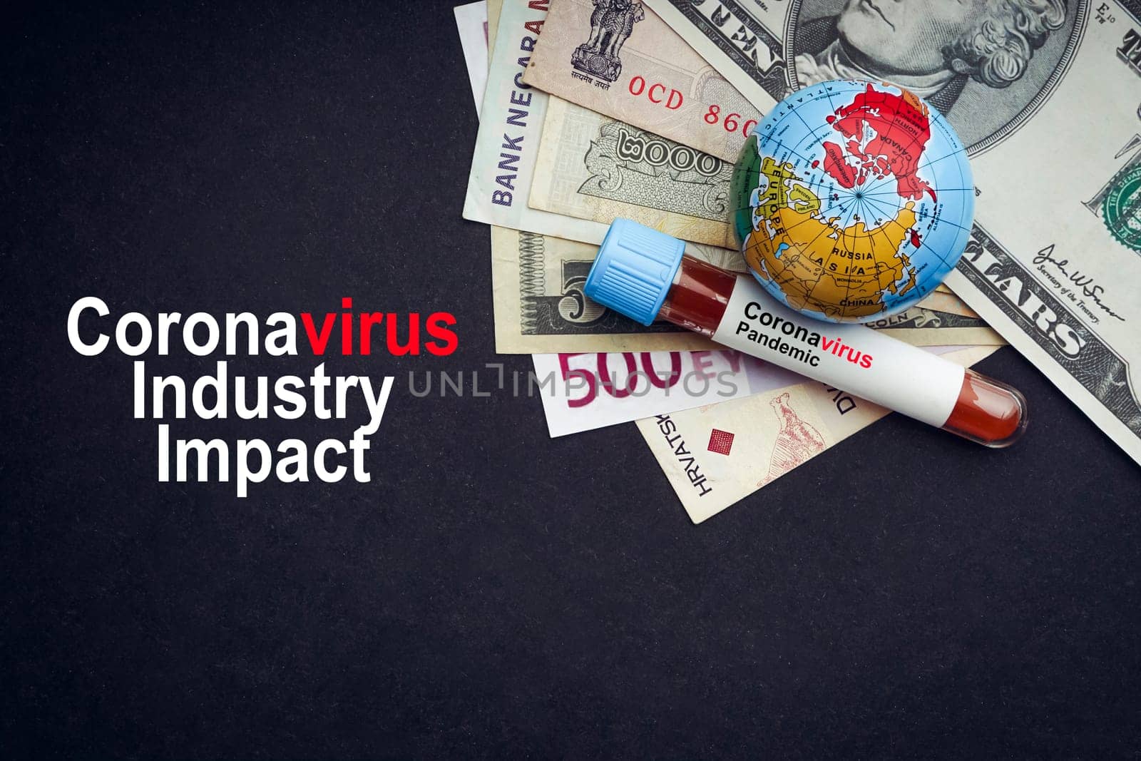 CORONAVIRUS INDUSTRY IMPACT text with currency banknotes, world globe and blood test vacuum tube on black background. Covid-19 or Coronavirus Concept