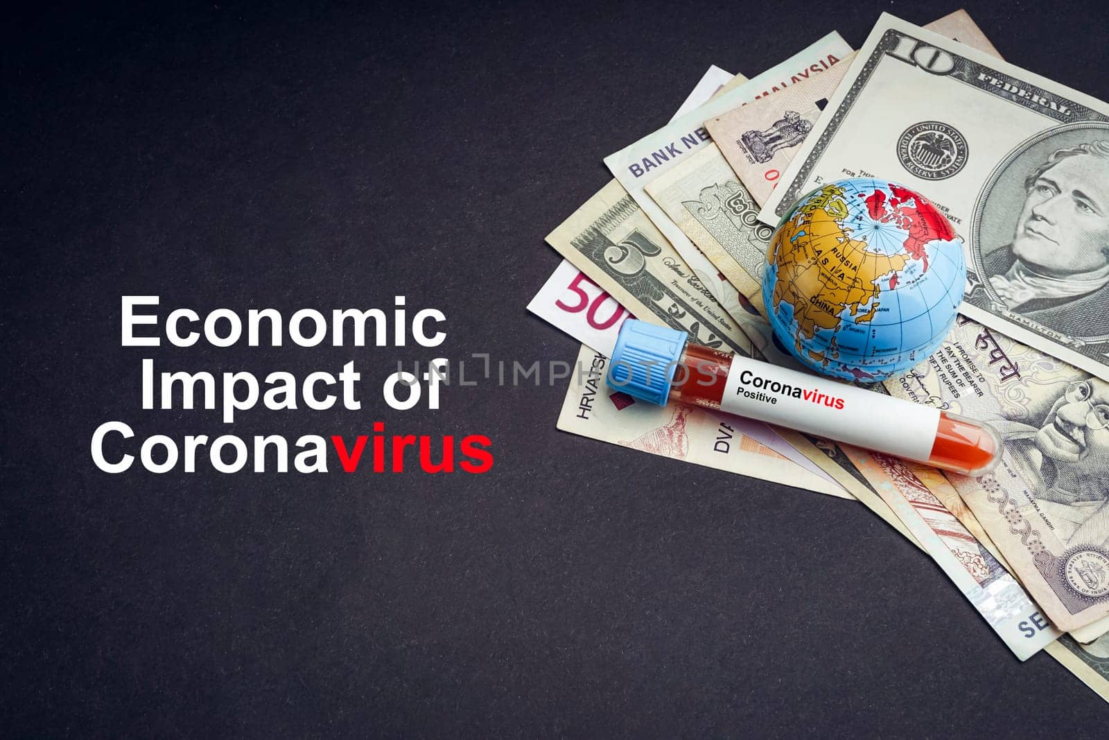 ECONOMIC IMPACT OF CORONAVIRUS text with currency banknotes, world globe and blood test vacuum tube on black background. Covid-19 or Coronavirus Concept