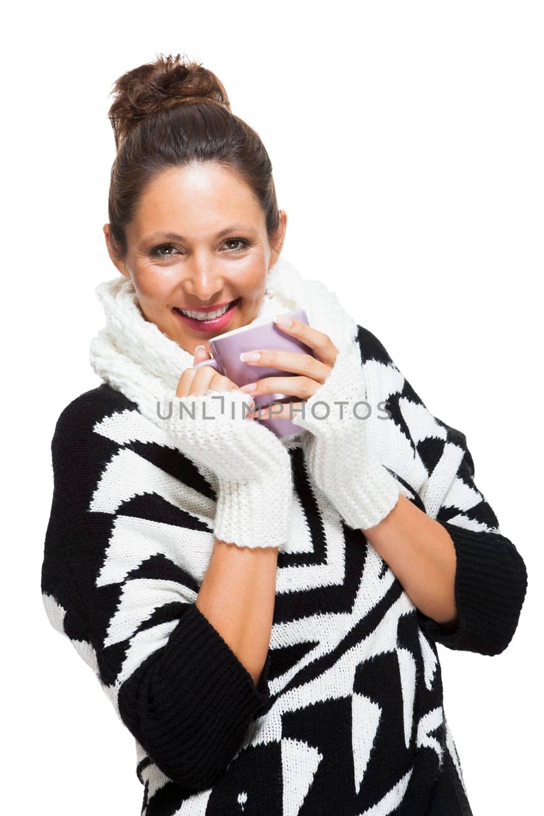 Young attractive woman with black white wool sweater drinks a cup of coffee or tea and warms her hands at the cup isolated on white background