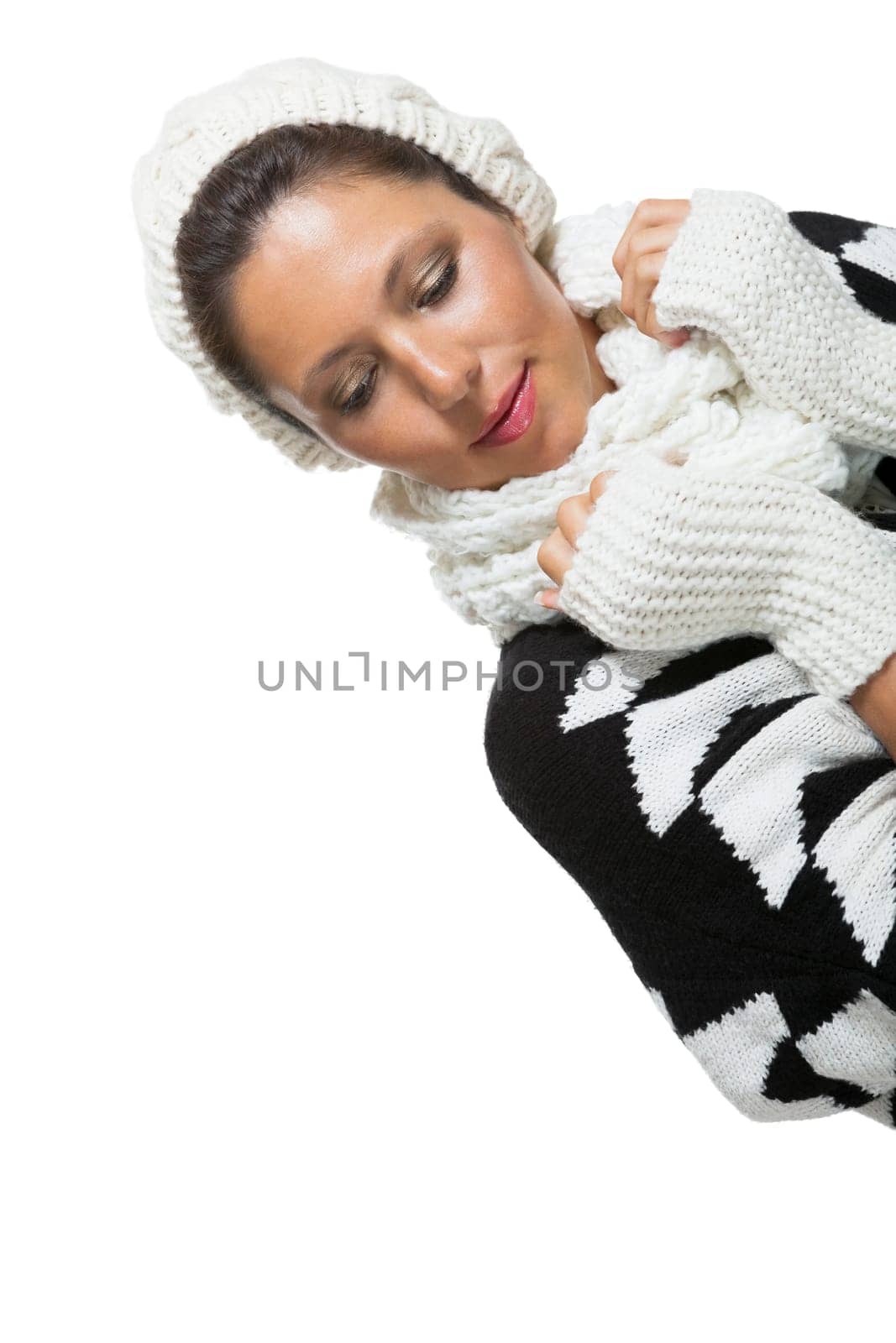 attractive young woman with white wool hat and knitted sweater scarf gloves with dark hair laughing isolated on white background