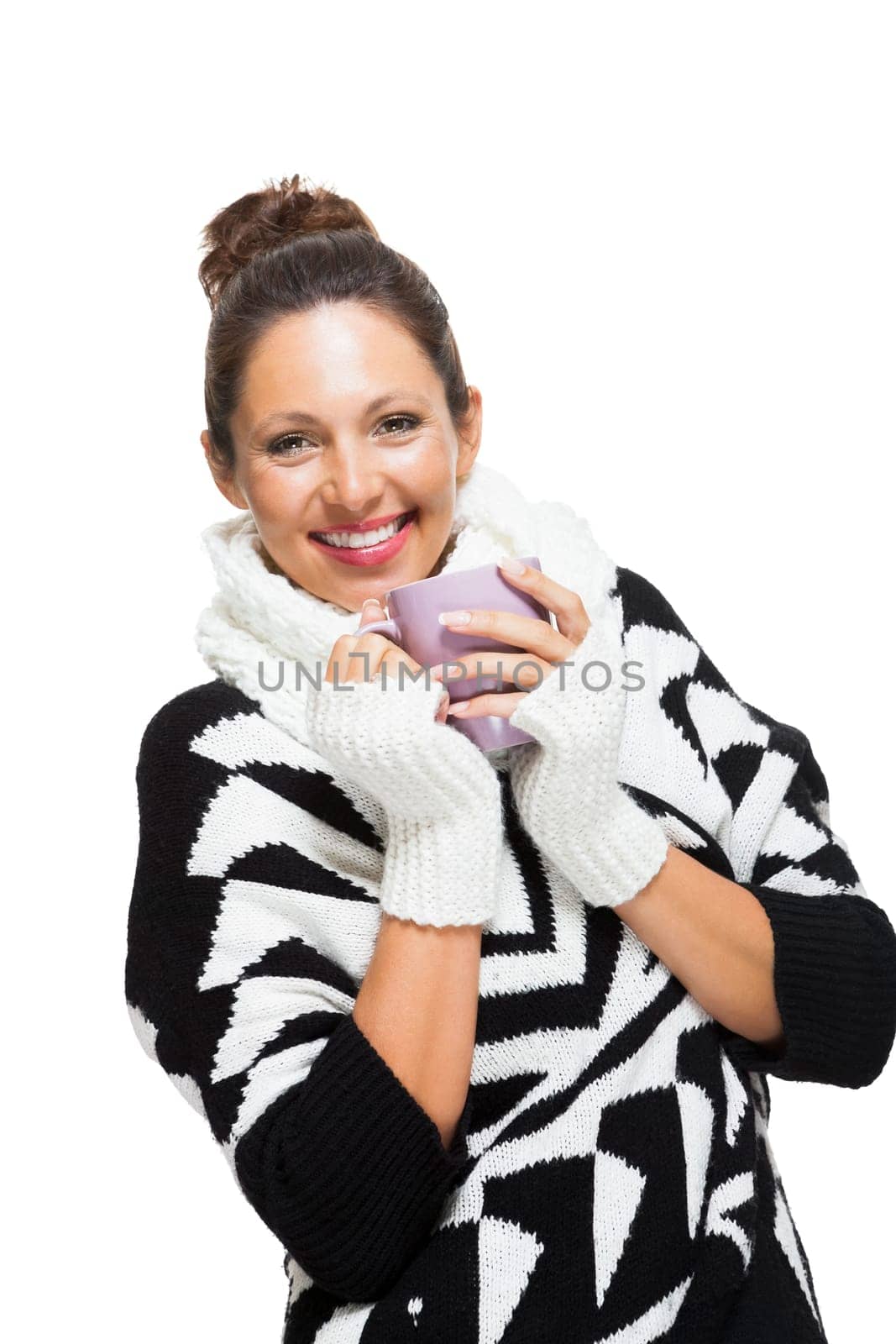 Young attractive woman with black white wool sweater drinks a cup of coffee or tea and warms her hands at the cup isolated on white background