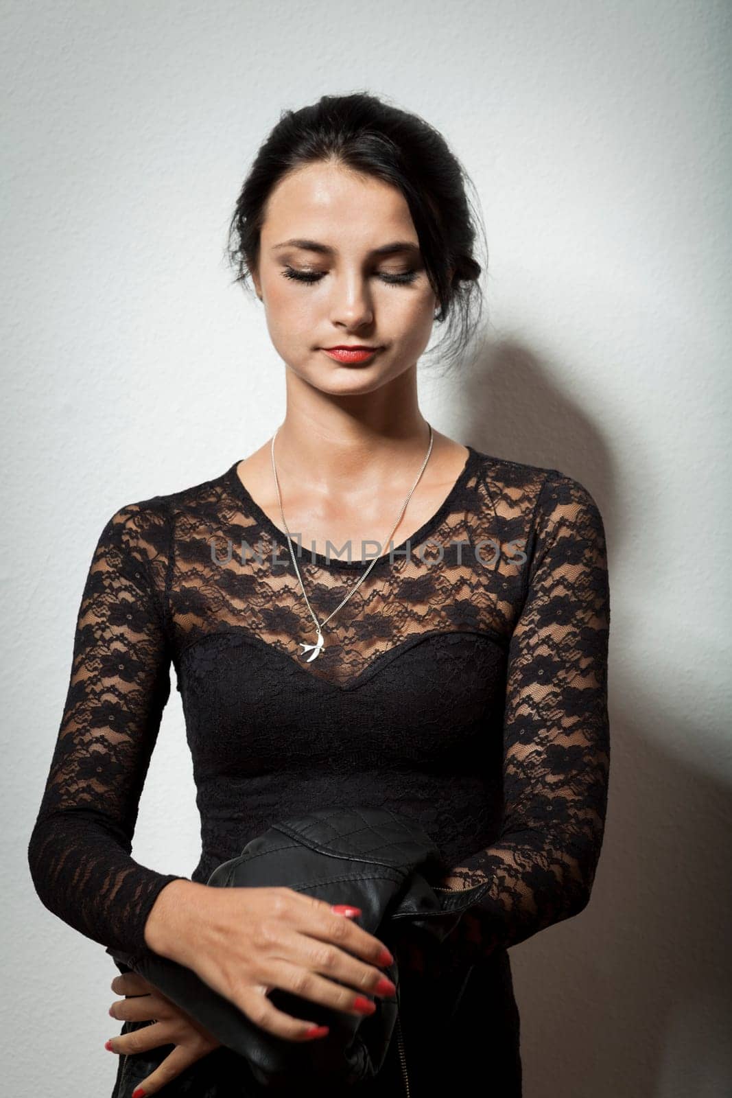 attractive woman with long dark hair in black cocktail dress as portrait with text space