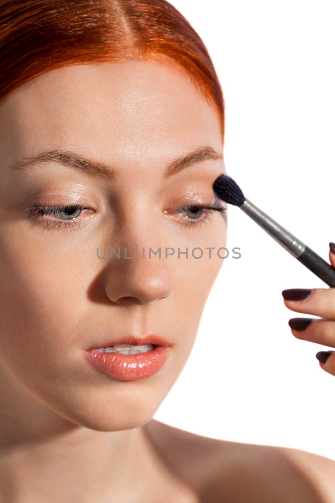 Young pretty woman with red hair wears makeup on nak shot portrait isolated against white background