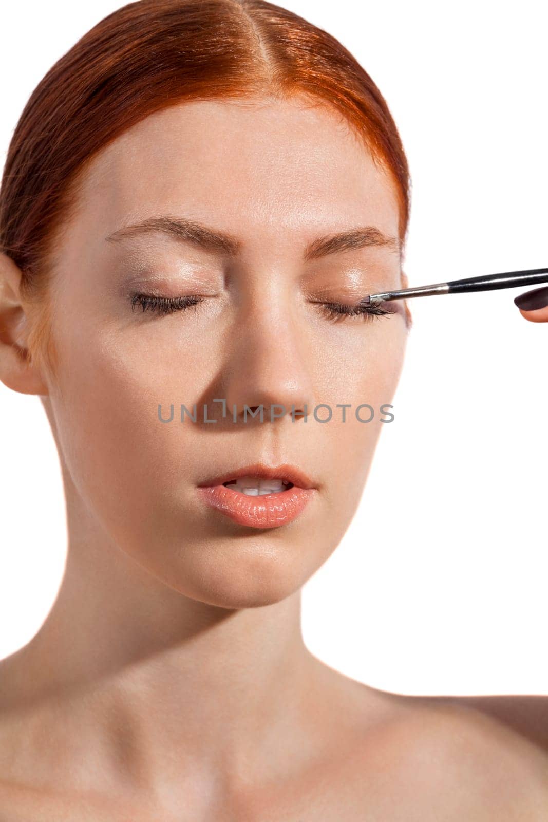 Young pretty woman with red hair wears makeup on nak shot portrait isolated against white background