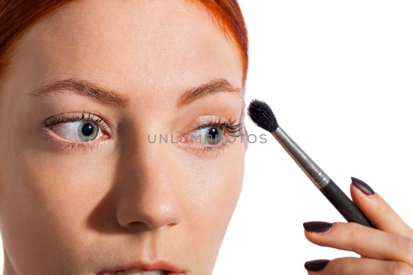 Young pretty woman with red hair wears makeup on nak shot portrait isolated against white background