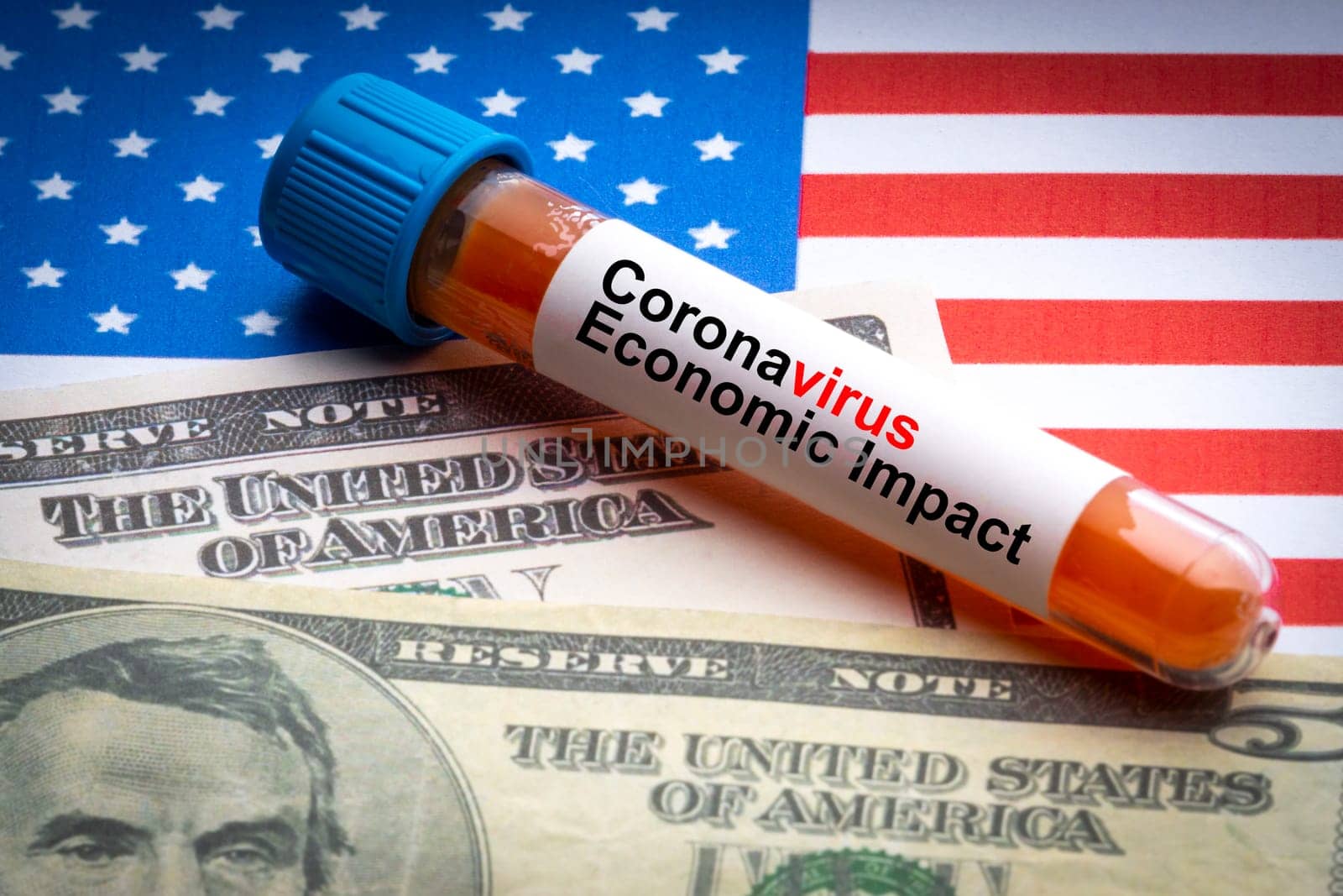 CORONAVIRUS ECONOMIC IMPACT text, US Dollar and blood sample vacuum tube on America flags background. Covid-19 or Coronavirus Concept