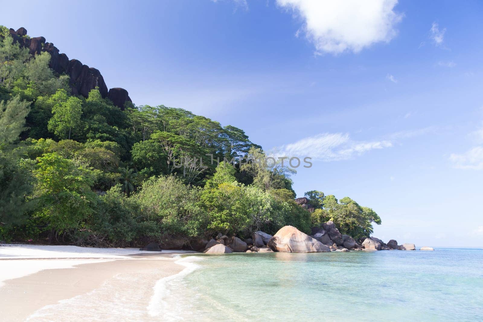 A beach on the Seychelles island with white sand and stones