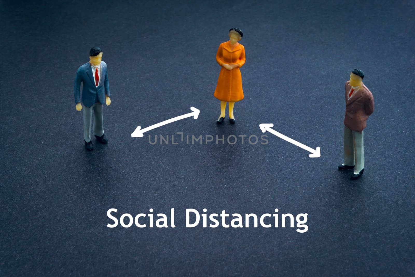 SOCIAL DISTANCING text with miniature people on dark background. Covid-19 or Coronavirus concept