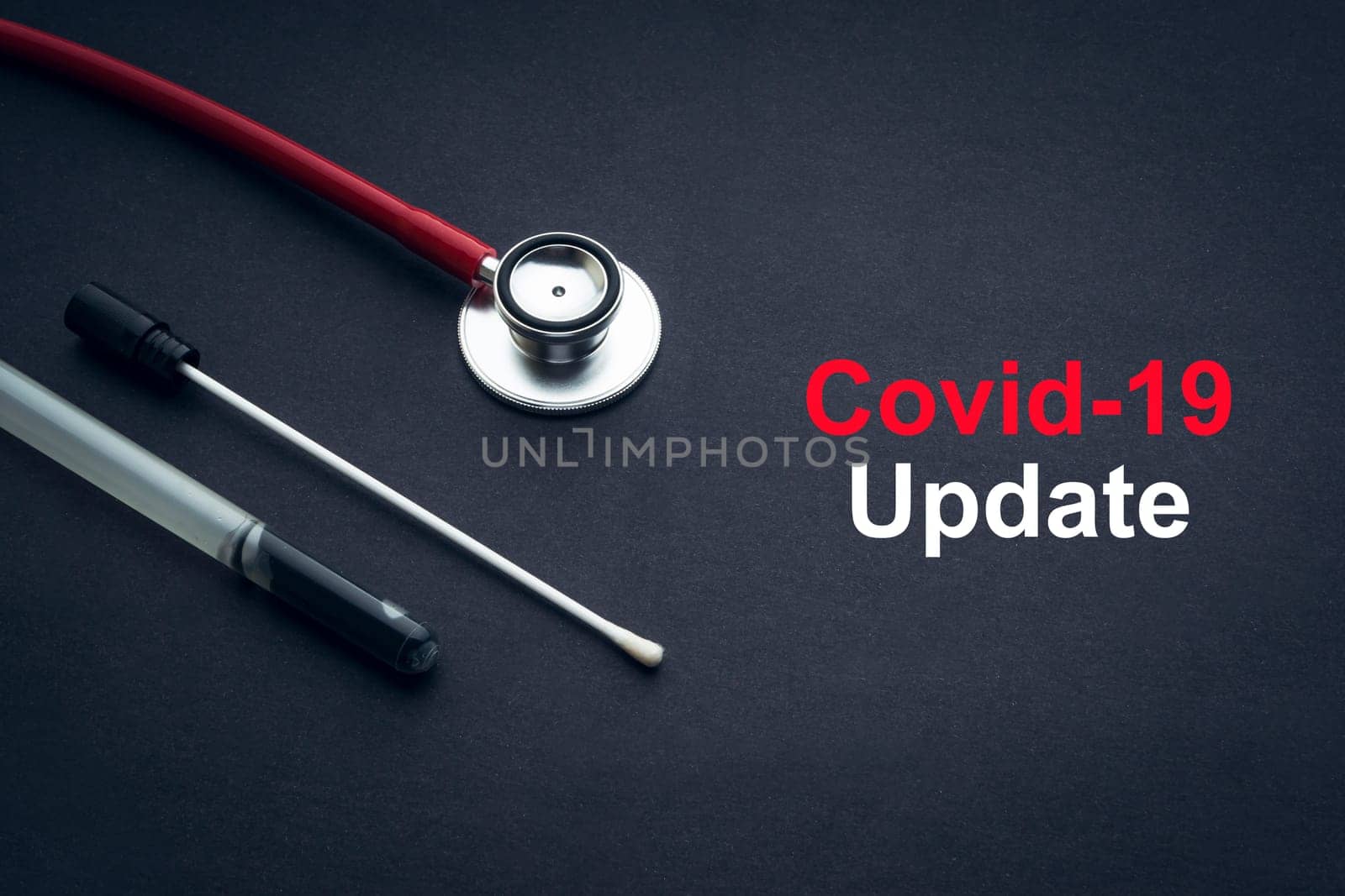 COVID-19 or CORONAVIRUS UPDATE text with stethoscope and medical swab on black background. Covid-19 or Coronavirus concept.