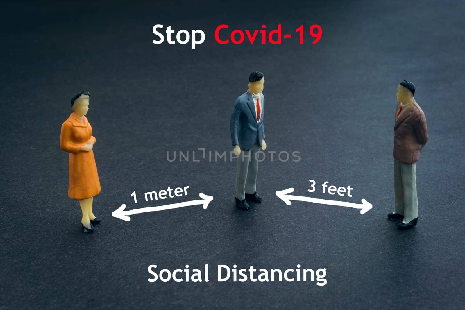 STOP COVID-19 SOCIAL DISTANCING text with miniature people on dark background. Covid-19 or Coronavirus concept