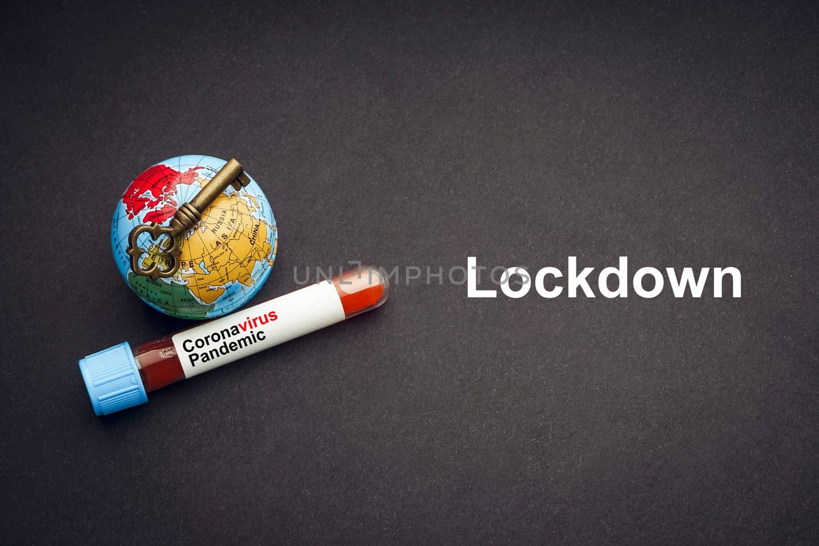 CORONAVIRUS LOCKDOWN text with world globe, key and Blood test vacuum tube on black background. Covid-19 or Coronavirus Concept