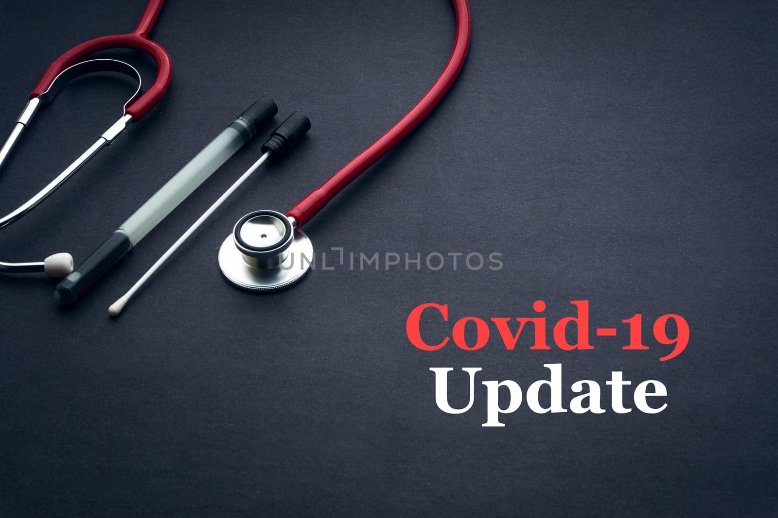 COVID-19 or CORONAVIRUS UPDATE text with stethoscope and medical swab on black background. Covid-19 or Coronavirus concept.