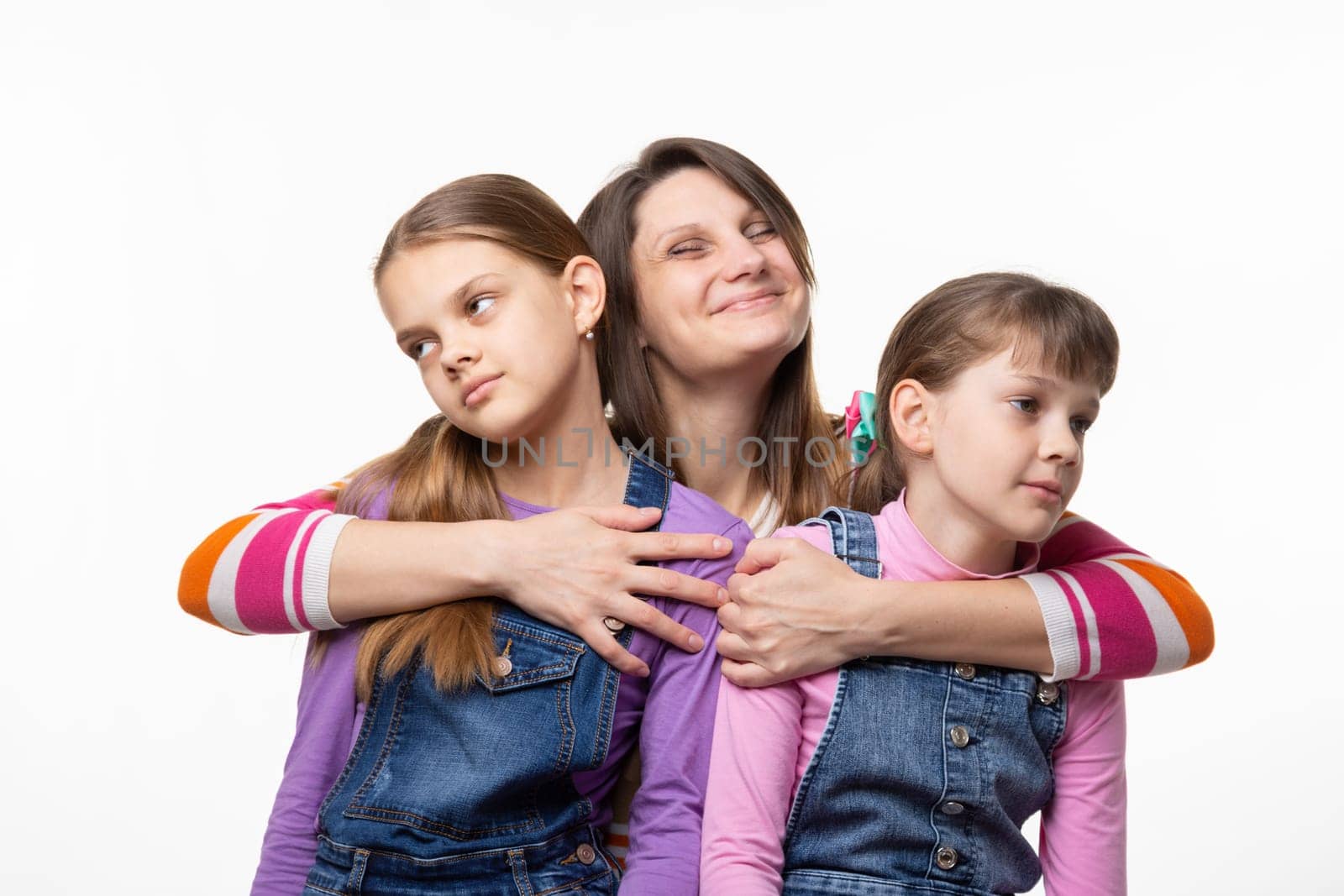 Mom happily hugs children, children turned away from mom