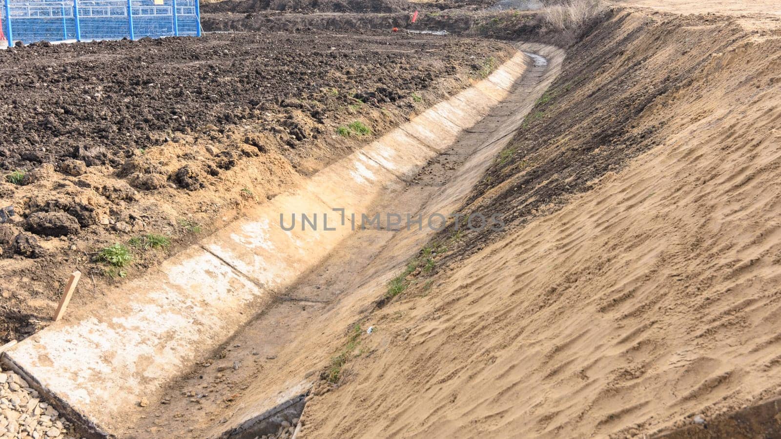 Construction of a drainage ditch along a road near an industrial facility