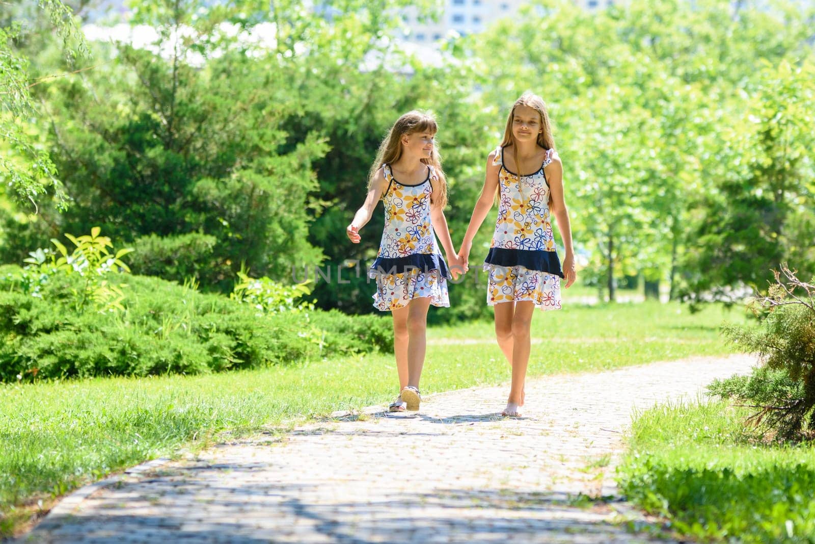 girls walk in the park and chat with each other