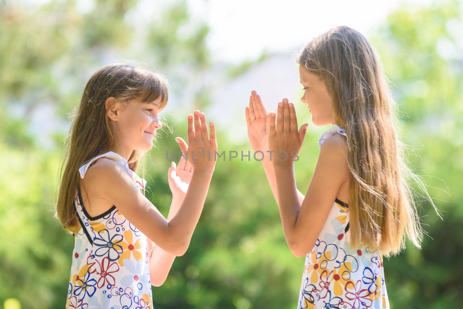 Children play ladlets walking in a city park, close-up