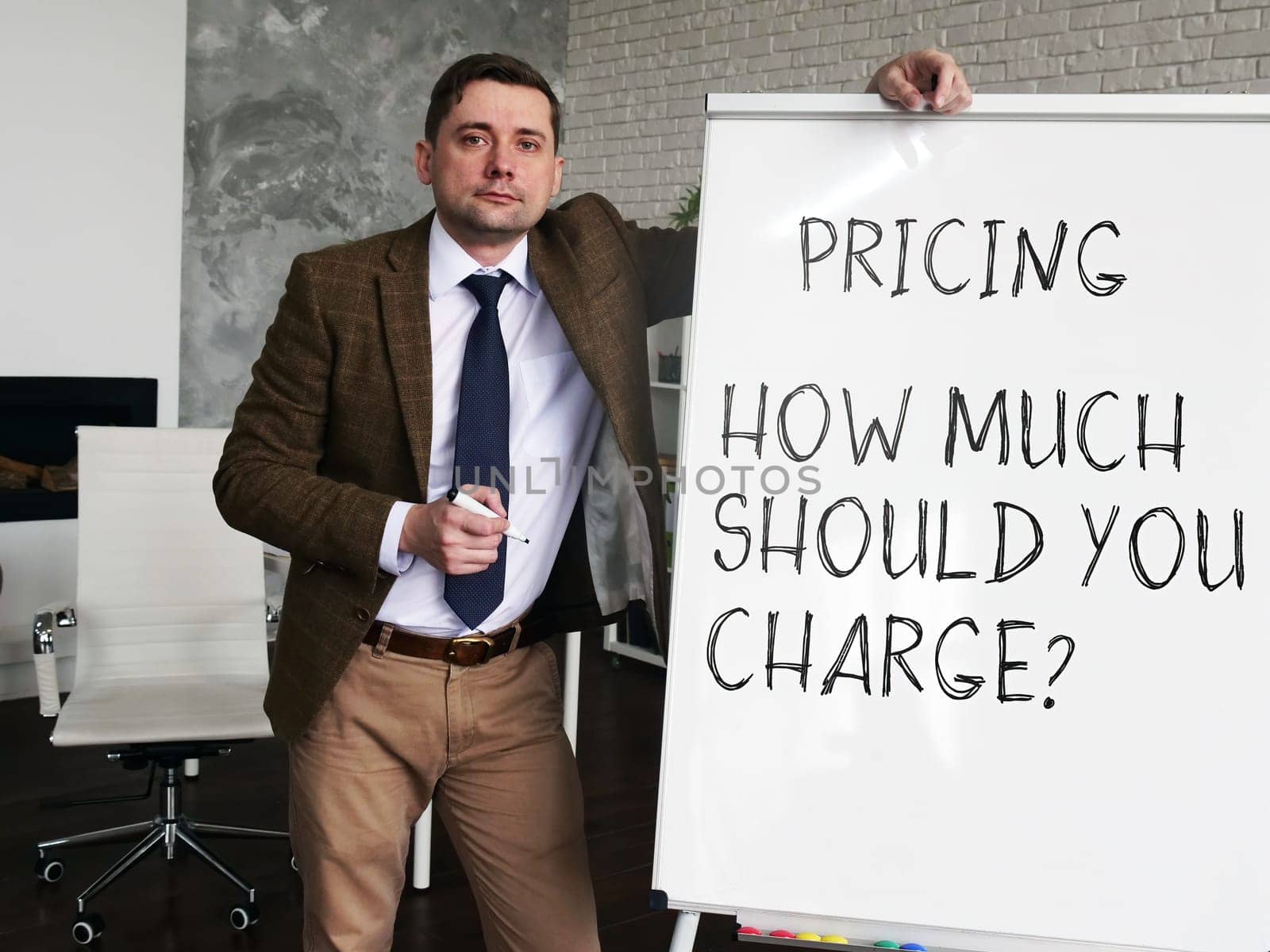 Pricing strategy - How Much Should You Charge. Business Advisor at the blackboard with the inscription.