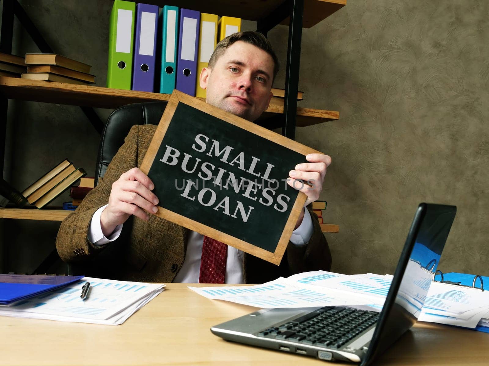Businessman shows phrase small business loan.