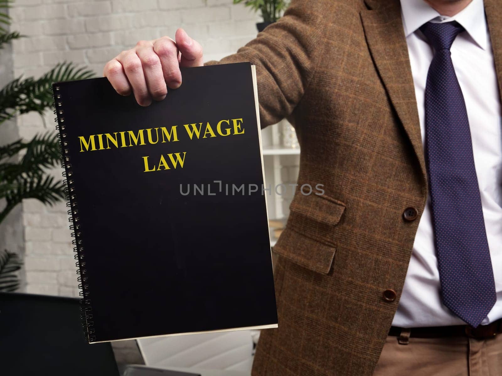 A man in a suit shows a book minimum wage law.