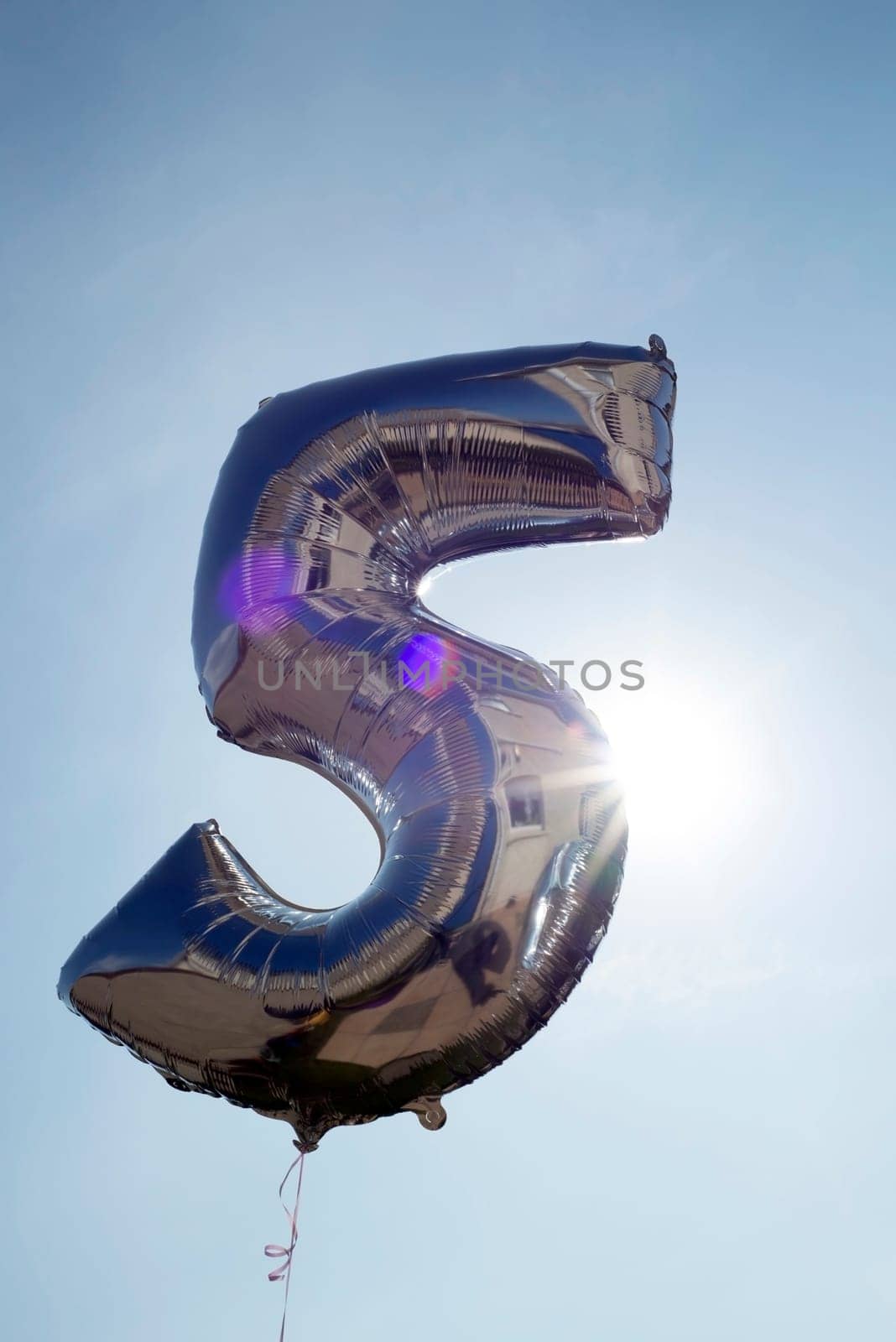 number 5 helium filled balloon against a blue sky
