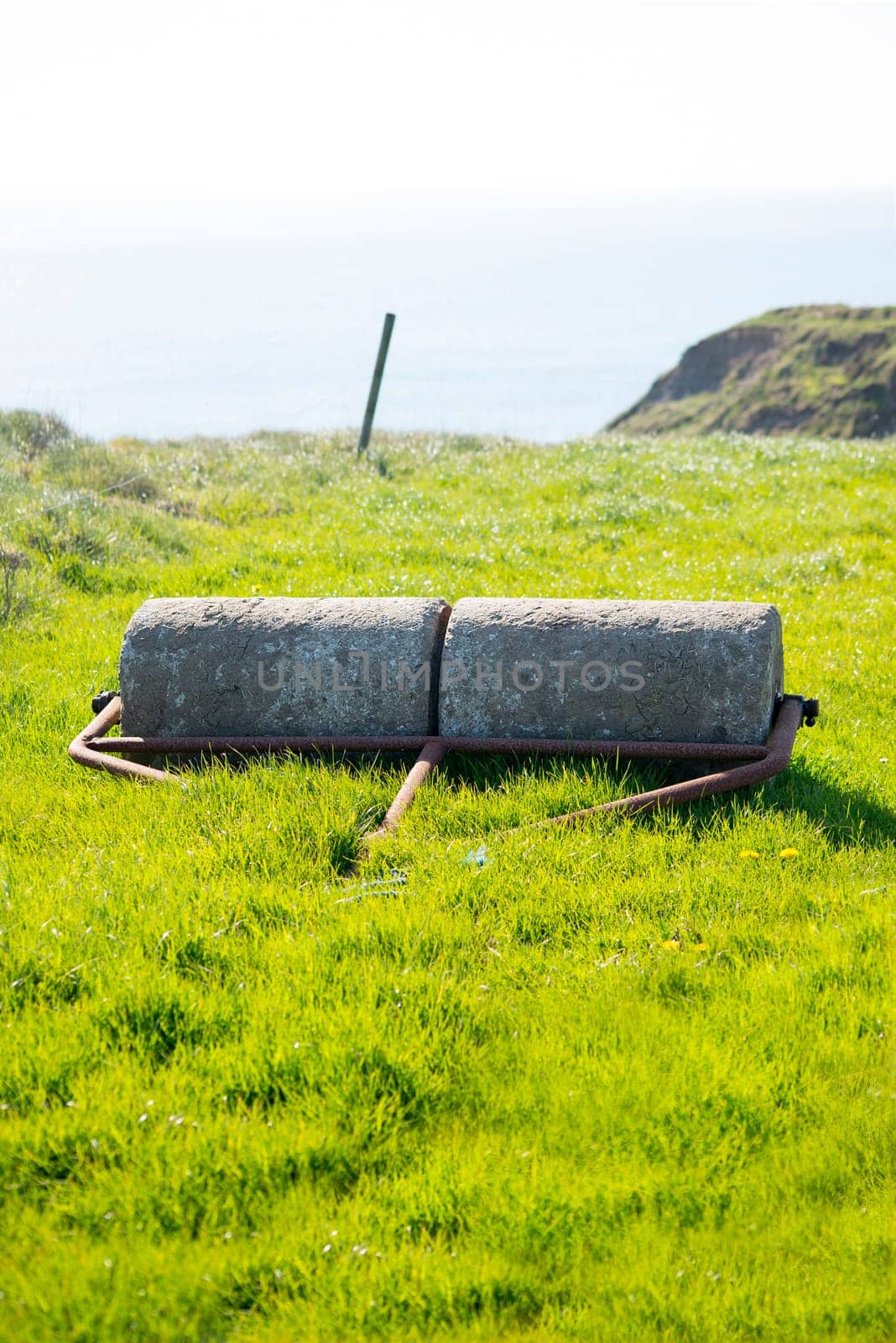 old rustic concrete roller abandoned at a field in ireland