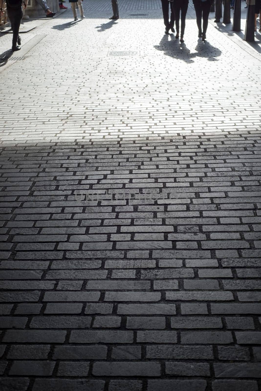 commuters walking down a cobbled lane in london city