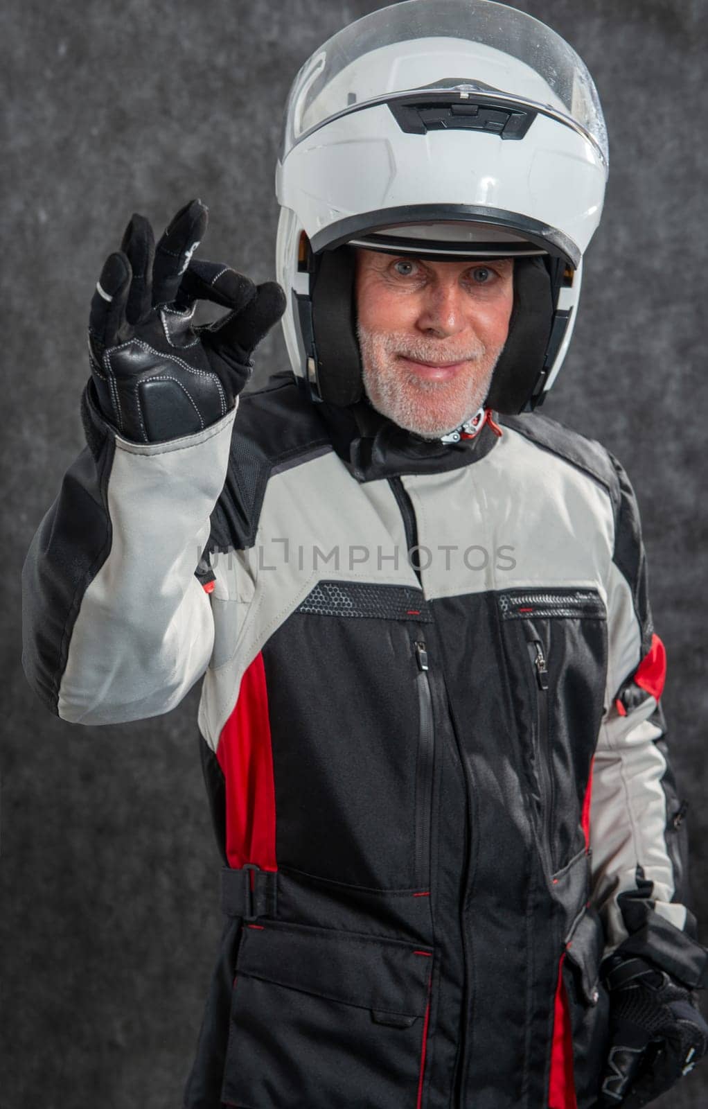 aportrait of senior biker with a white helmet make OK
