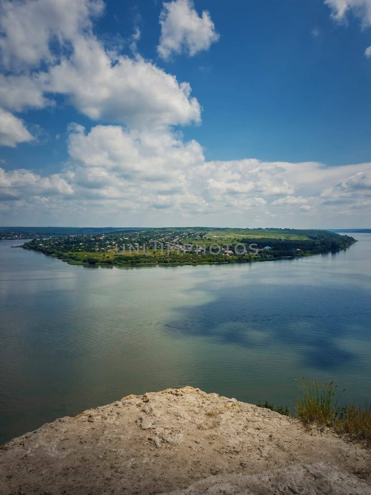 High angle, altitude view to the Nistru river, near Dubasari (Dubossary), Transnistria, Moldova. Idyllic vertical orientation scene on the peak of a cliff over the water under a rich blue sky.