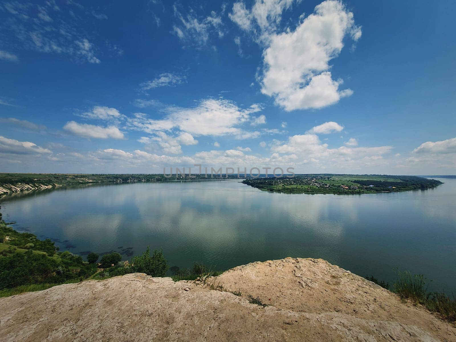 High angle, altitude view to the Nistru river, near Dubasari (Dubossary), Transnistria, Moldova. Idyllic panoramic scene on the peak of a cliff over the water under a rich blue sky.