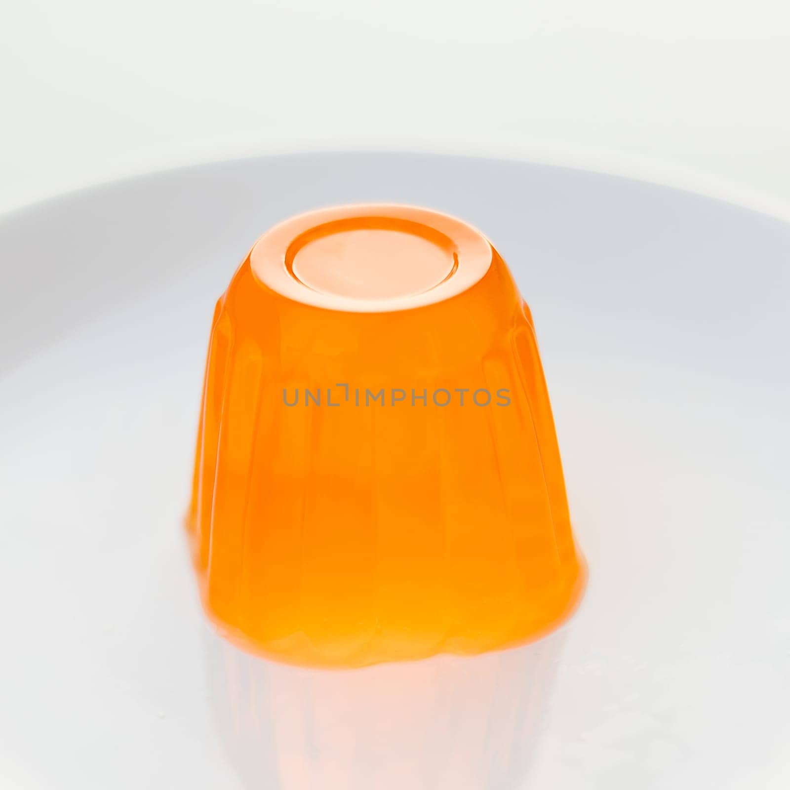 Close up of a orange gelatin on a white plate.