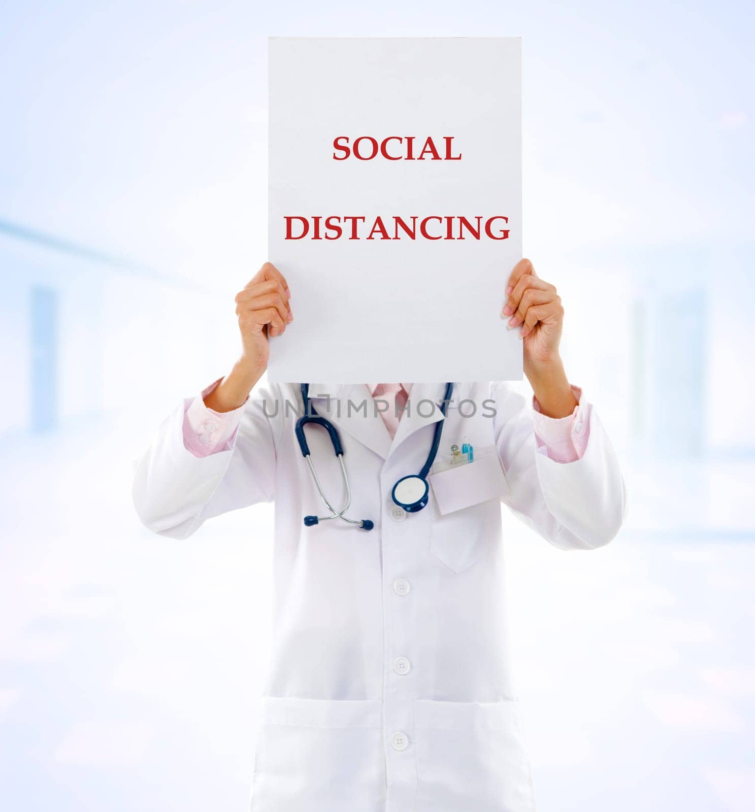 Medical doctor holding a card with social distancing on it.