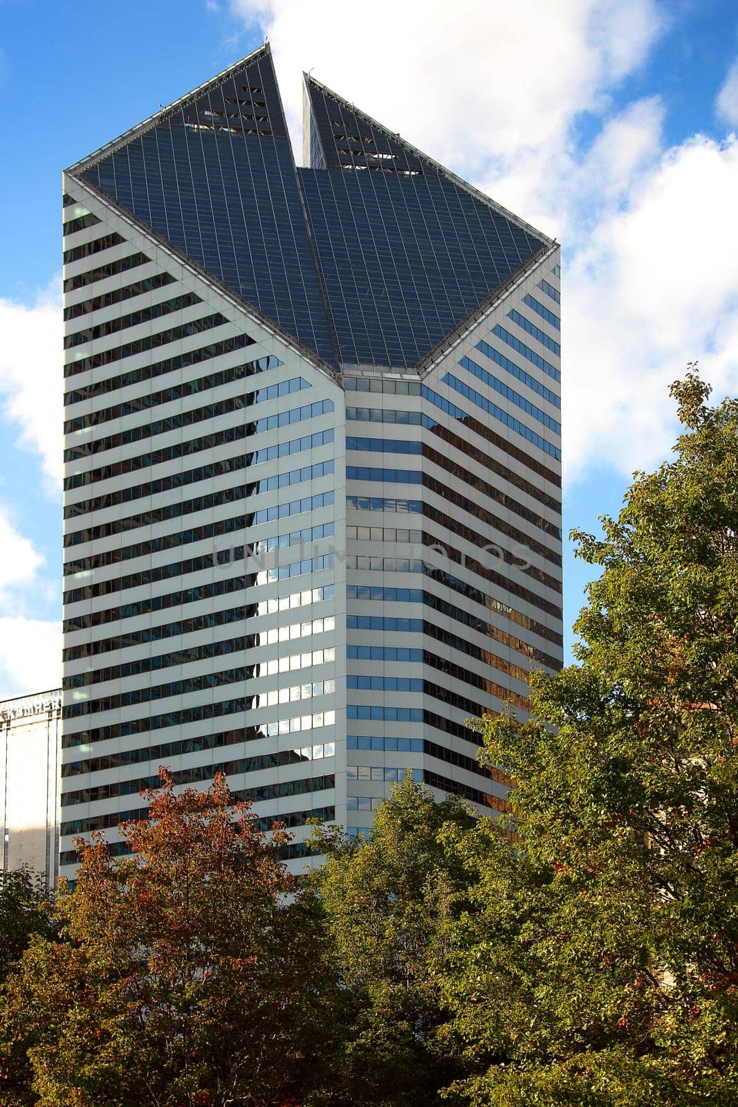 CHICAGO, ILLINOIS/USA-OCTOBER 16 2015: Crain Communications Building Chicago with autumn trees Millennium Park on October 16 2015, Chicago, Illinois