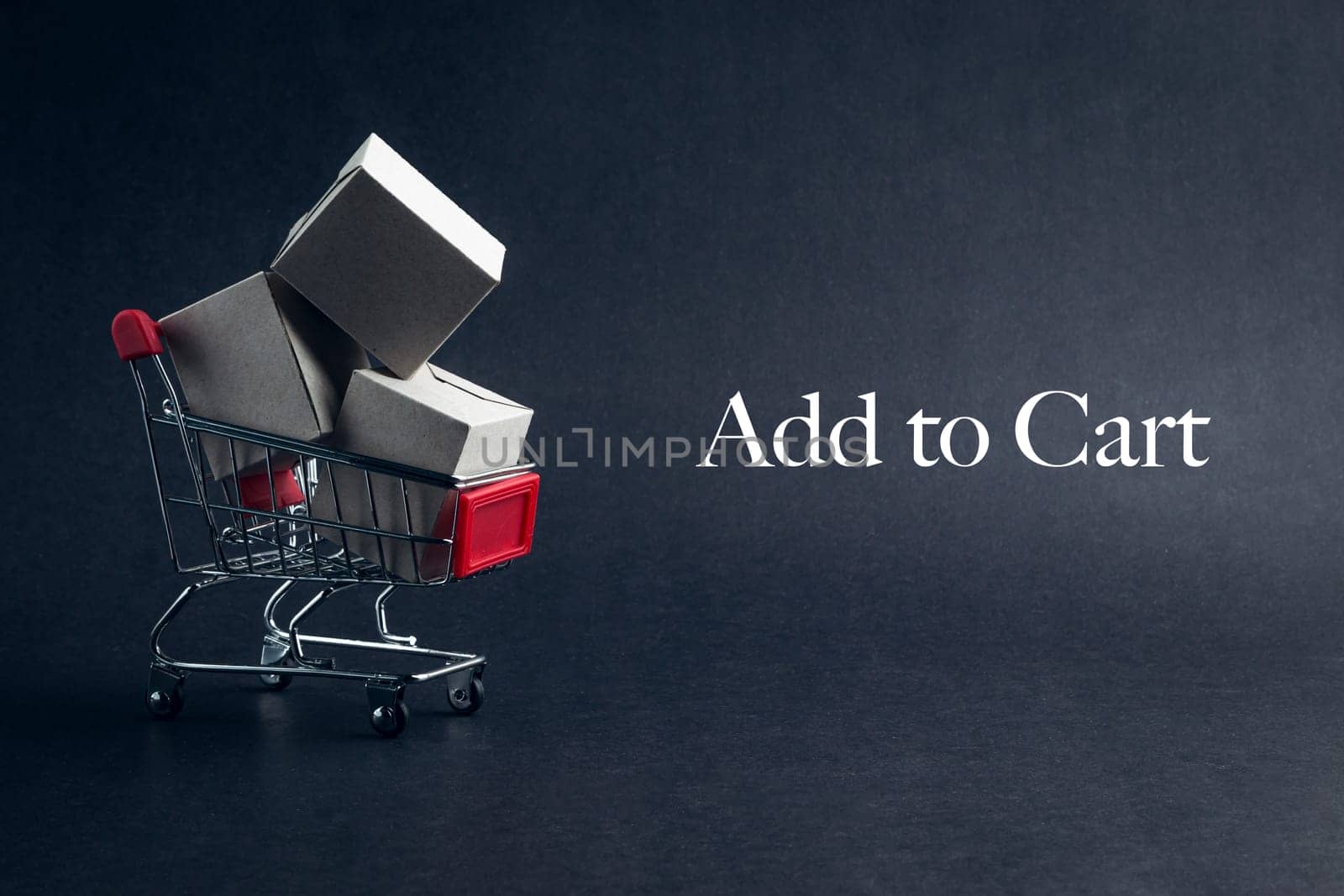 Shopping cart with words ADD TO CART on dark background. Business, Copy space and online shopping concept. Selective focus