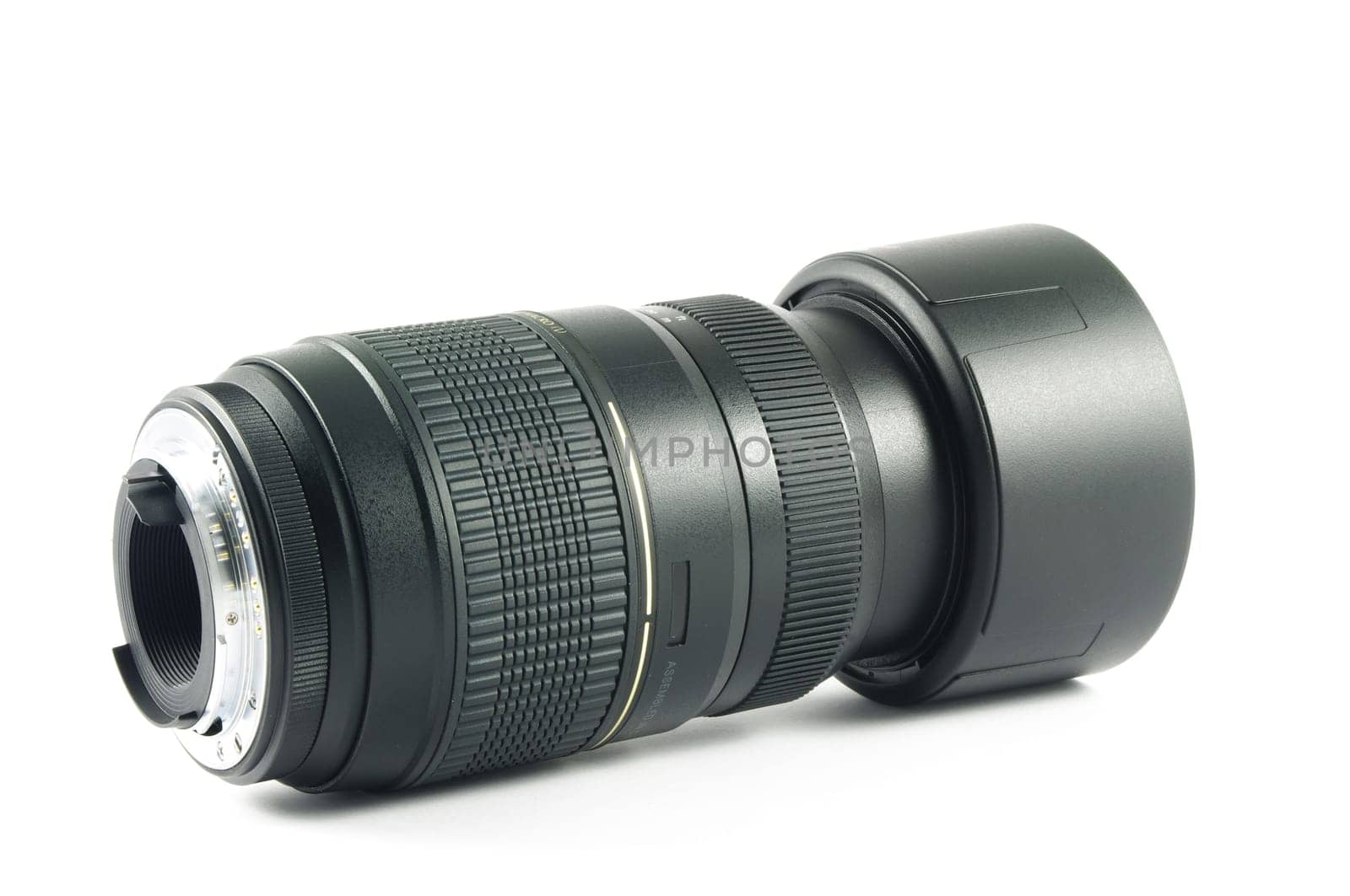Camera lens with hood lying on the white surface