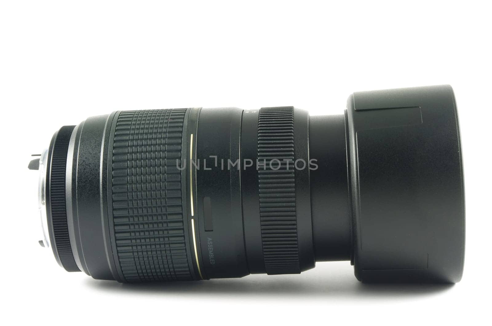 Camera lens with hood lying on the white surface