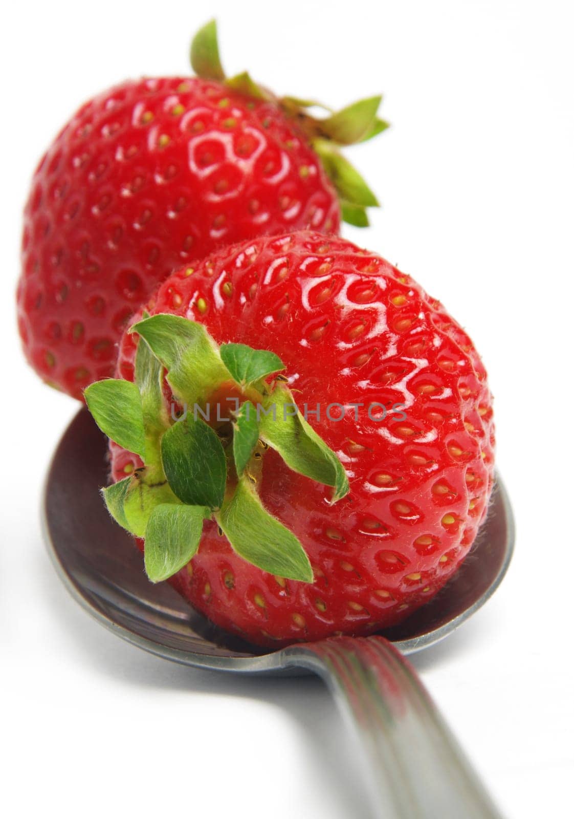 strawberry closeup on the spoon over white