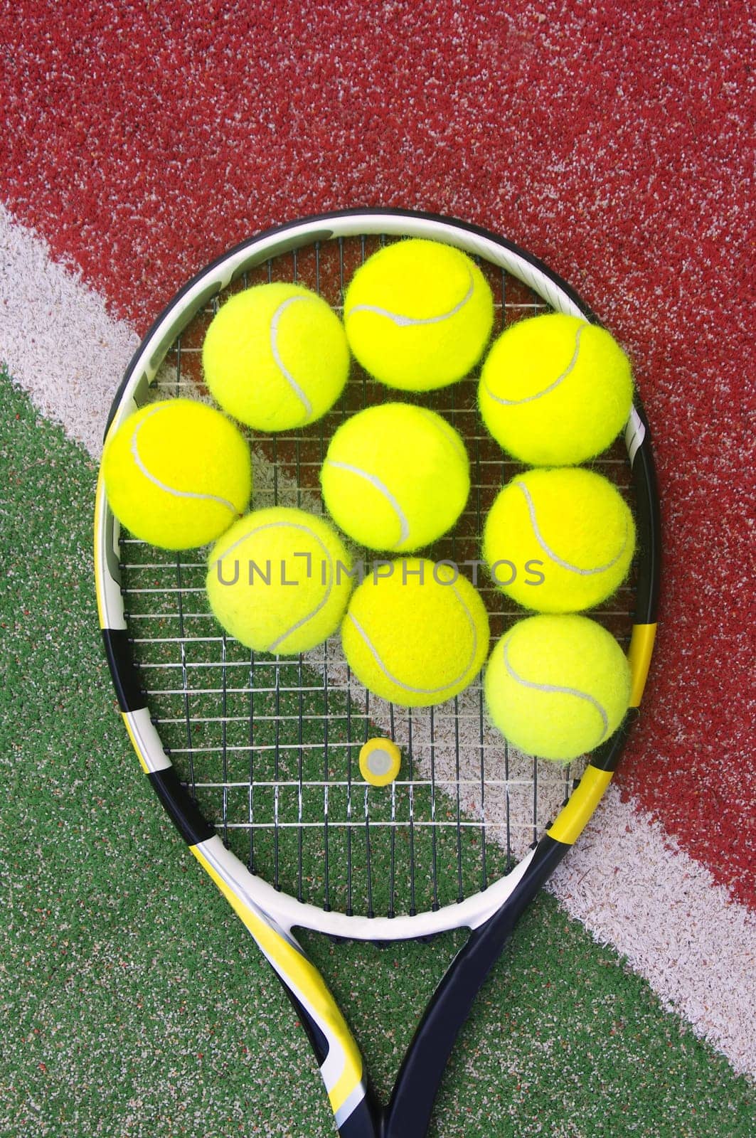 tennis racket with balls on court