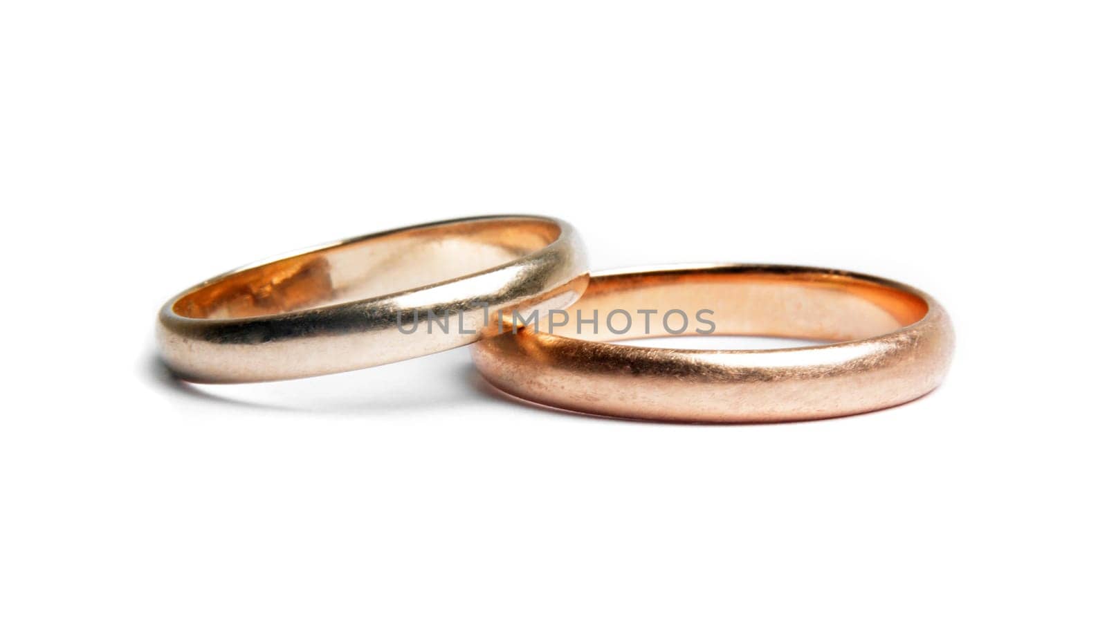 two worn golden rings on white