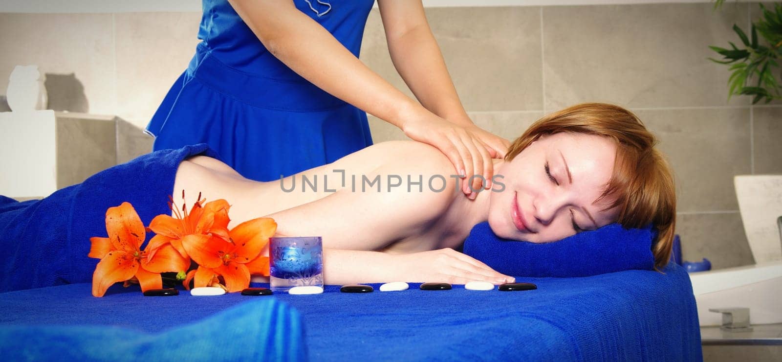 blond woman getting massage in spa salon
